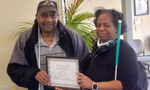 Robert receiving his certificate of completion from Sabrina, a BISM Senior ITR Instructors.