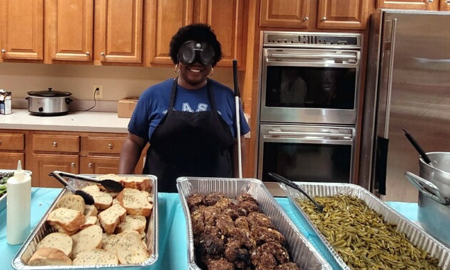 Samantha Ashmore stands over meal she helped prepare in the BISM kitchen.