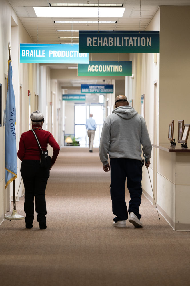 Two seniors walking down a hallway