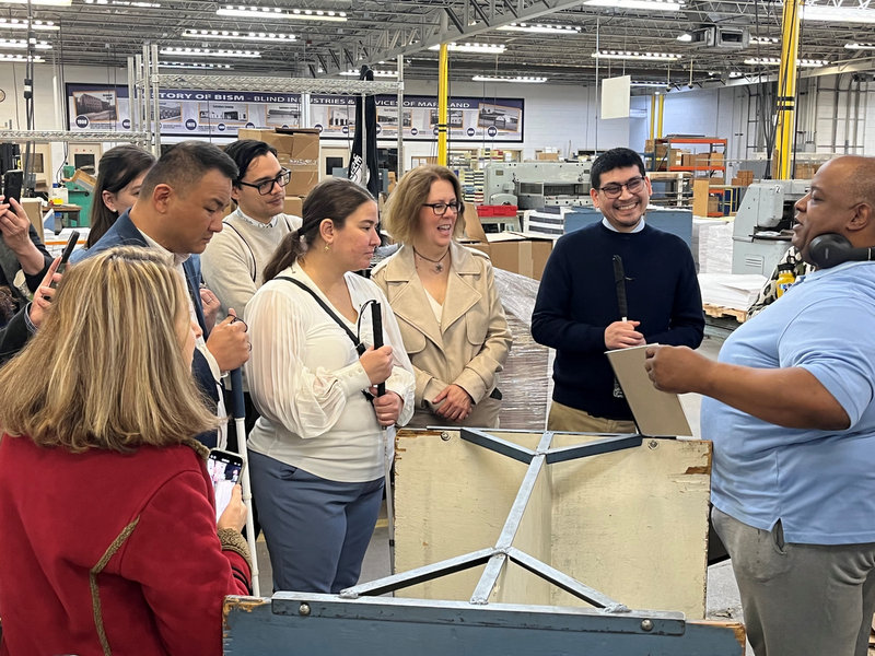 Group of blind and low vision people receiving a tour of BISM facilities