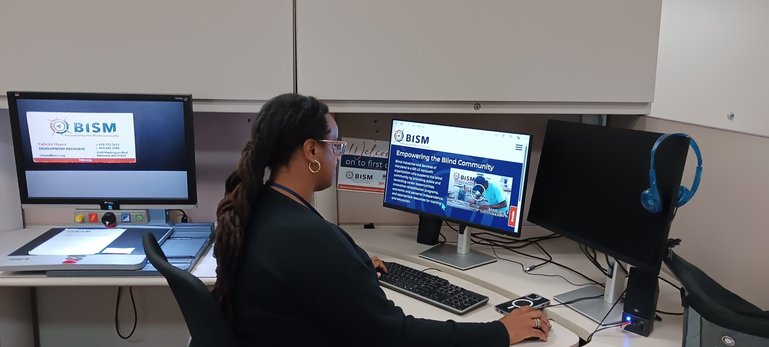 BISM Employee at their desk, using all the accessibility tools - screen reader, magnifier and other tools.