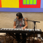 Sunny playing the piano at an event reception.