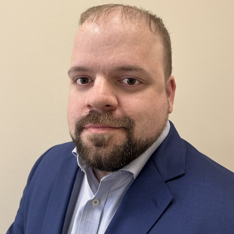 Headshot of Shane Jones wearing a blue blazer.