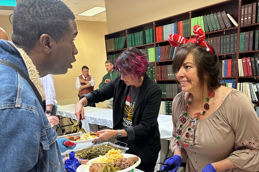 Baltimore Associates chat while staff members serve holiday meal