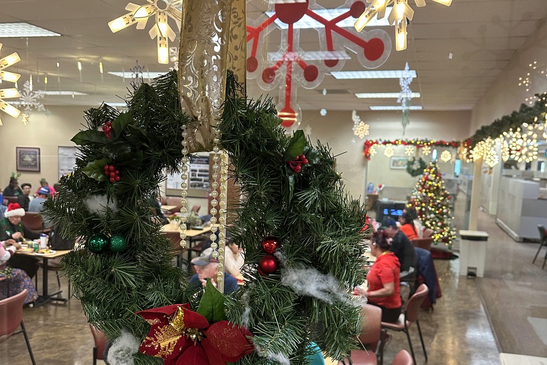 wreath decoration hangs in front of associates enjoying holiday party