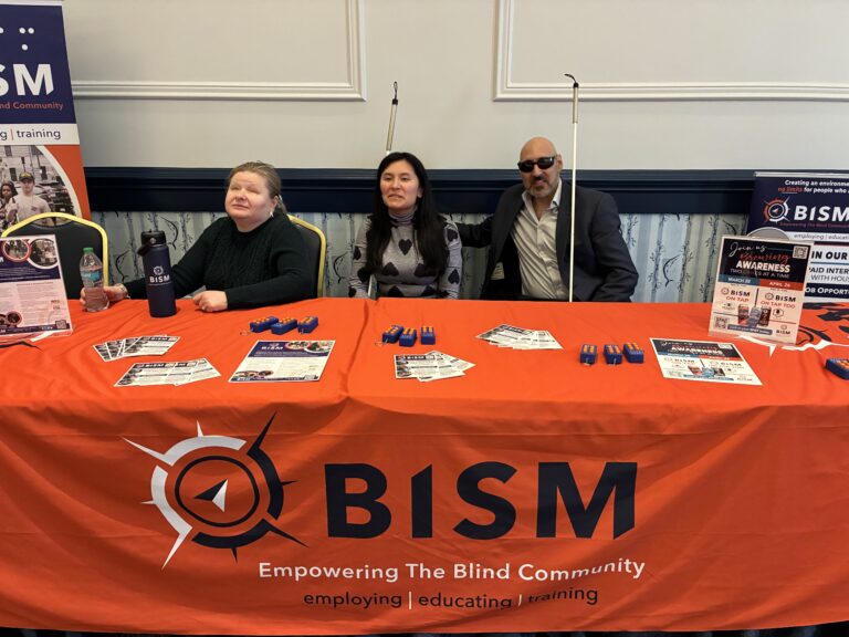 Matt Bonnie and Lena (BISM employees) sitting at the BISM exhibit hall table