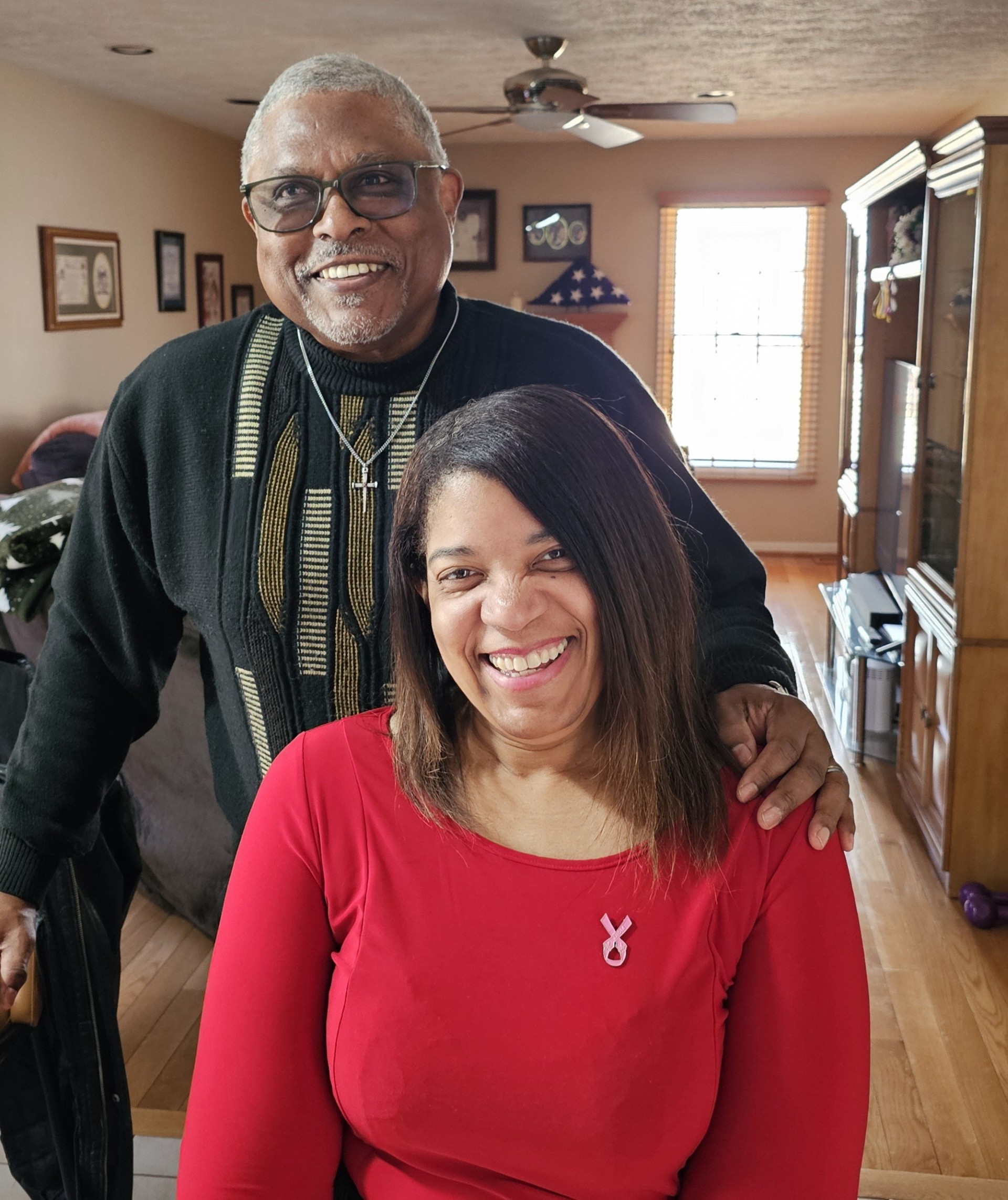 Tyrone Bullock Sr. smiling with his arm around his wife, who is also smiling.